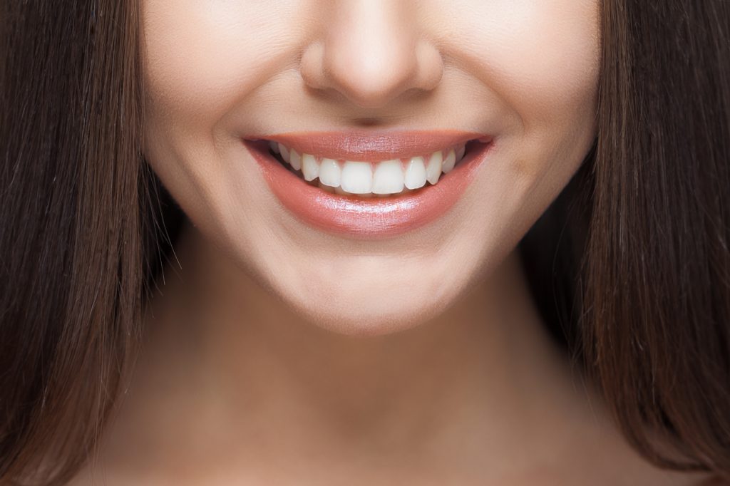 A woman smiles after taking dental services near me